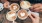 a group of hands holding cups of coffee with foam on the top